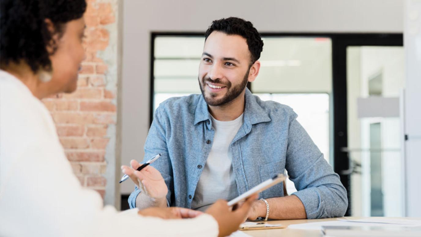 A woman advises a customer at a desk