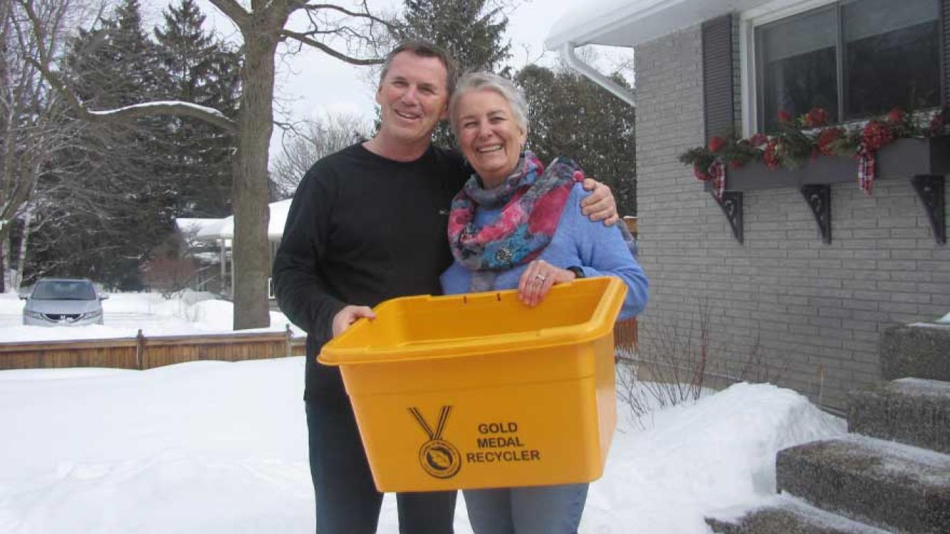 Man and women holding new gold recycling bin