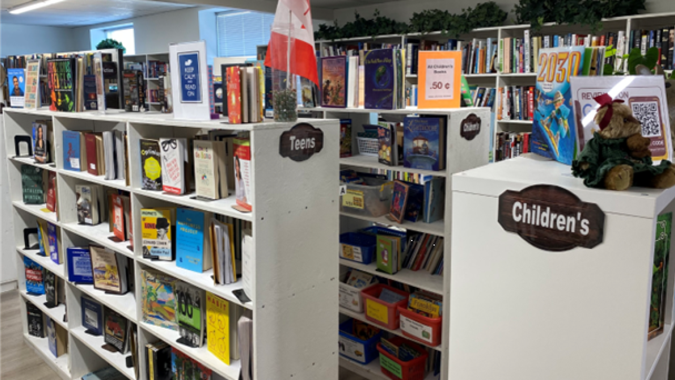 Bookshelves labeled for Teens and Children, filled with colorful books. 