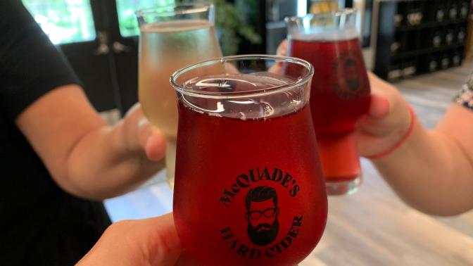 Three Hands holding glass of beer