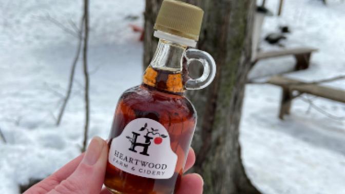 hand holding small bottle of maple syrup
