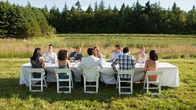 People at an outdoor dinner party on a farm