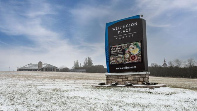 Large digital sign reads "Wellington Place Campus," the museum and OPP buildings can be seen in the background