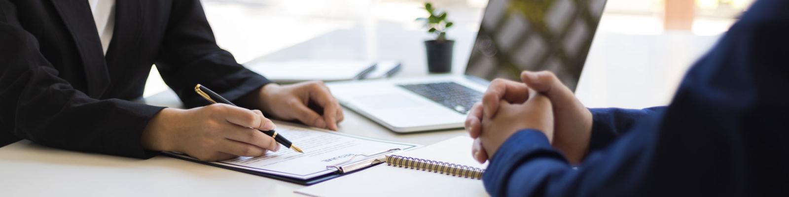 Cropped image of an employer reviewing a potential employees resume across from one another at a desk