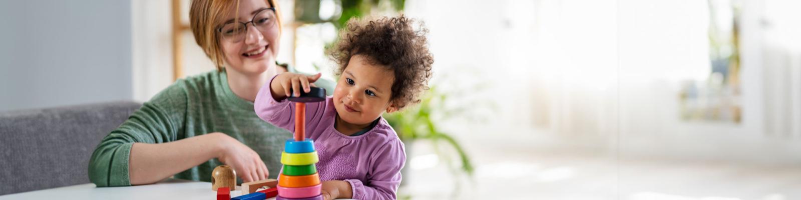 Preschool teacher with a child playing with didactic toys