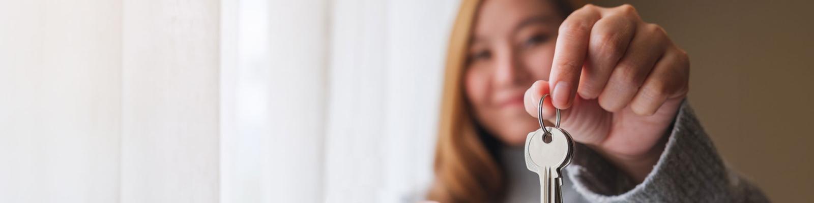 Smiling woman holding out a set of house keys