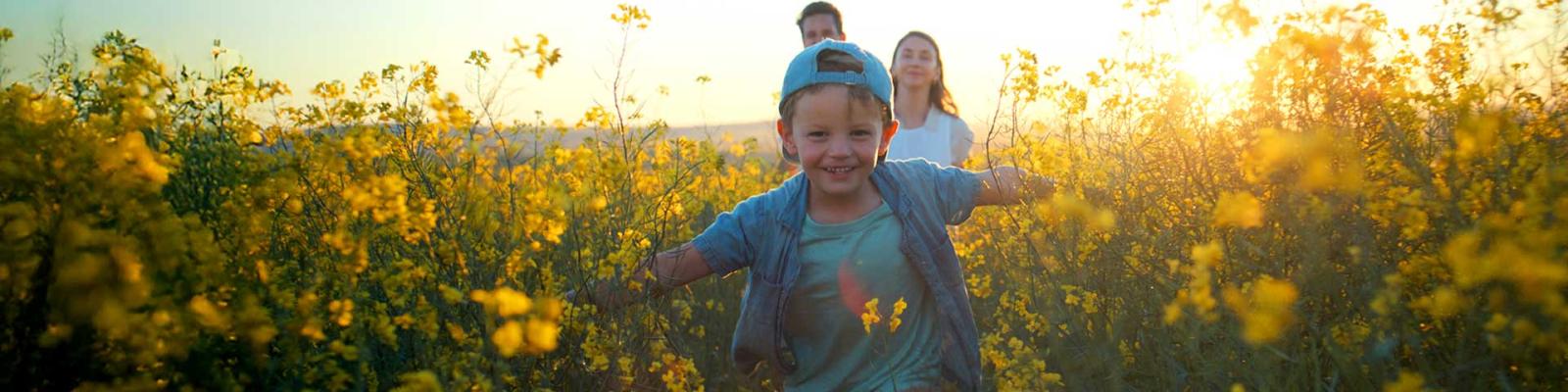 family running through field of spring flowers