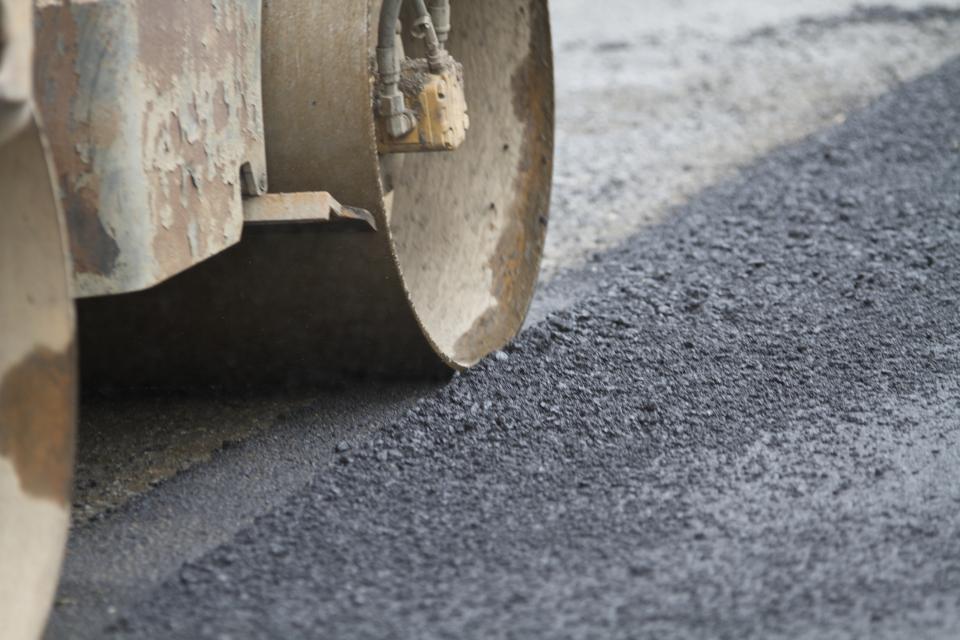 A roller flattens recent road work. 