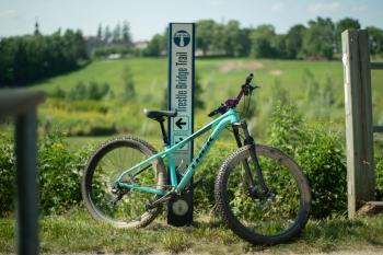 Teal bike leaning against Tressle Bridge Sign