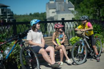 kids and mom with bikes in elora sitting on a bench