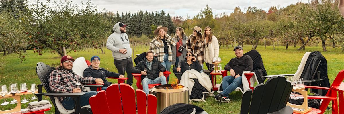 people sitting around a campfire with drinks