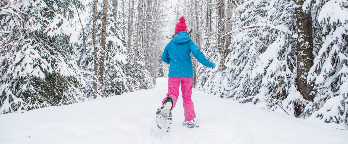 person running through snow on a trail with snowshoes