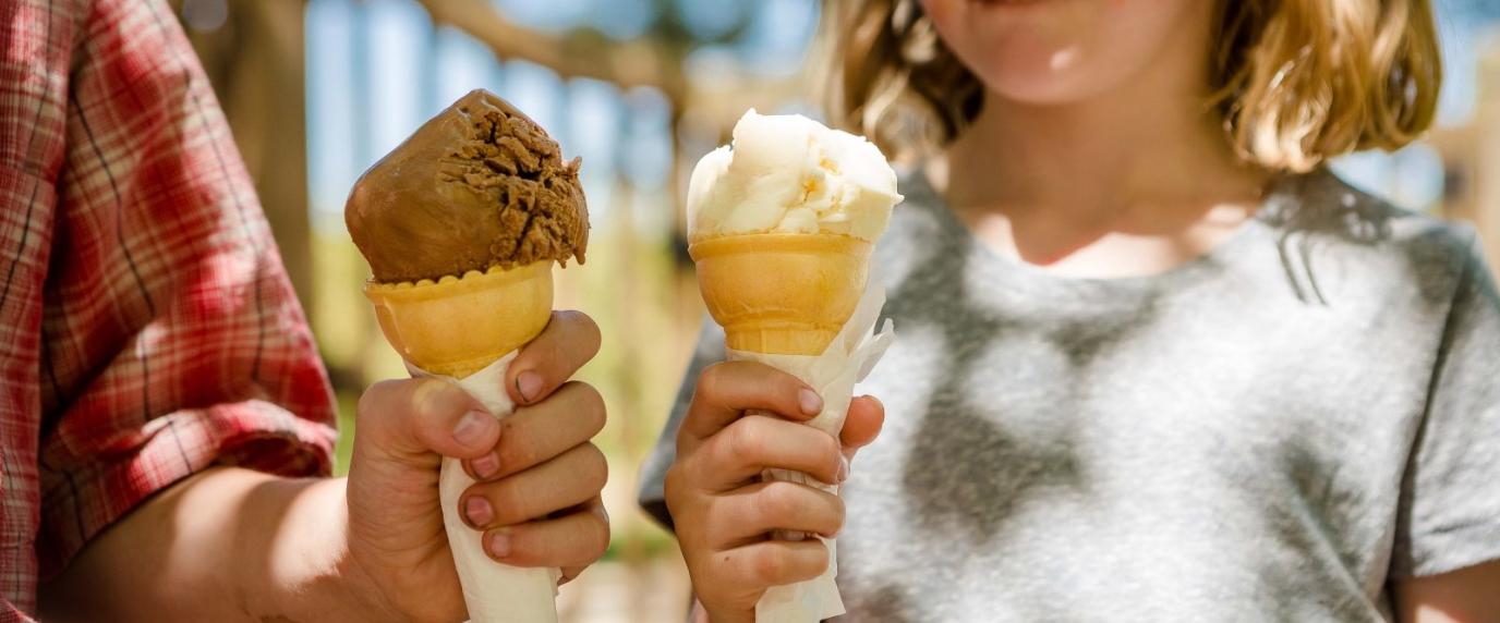 two hands holding ice cream cones