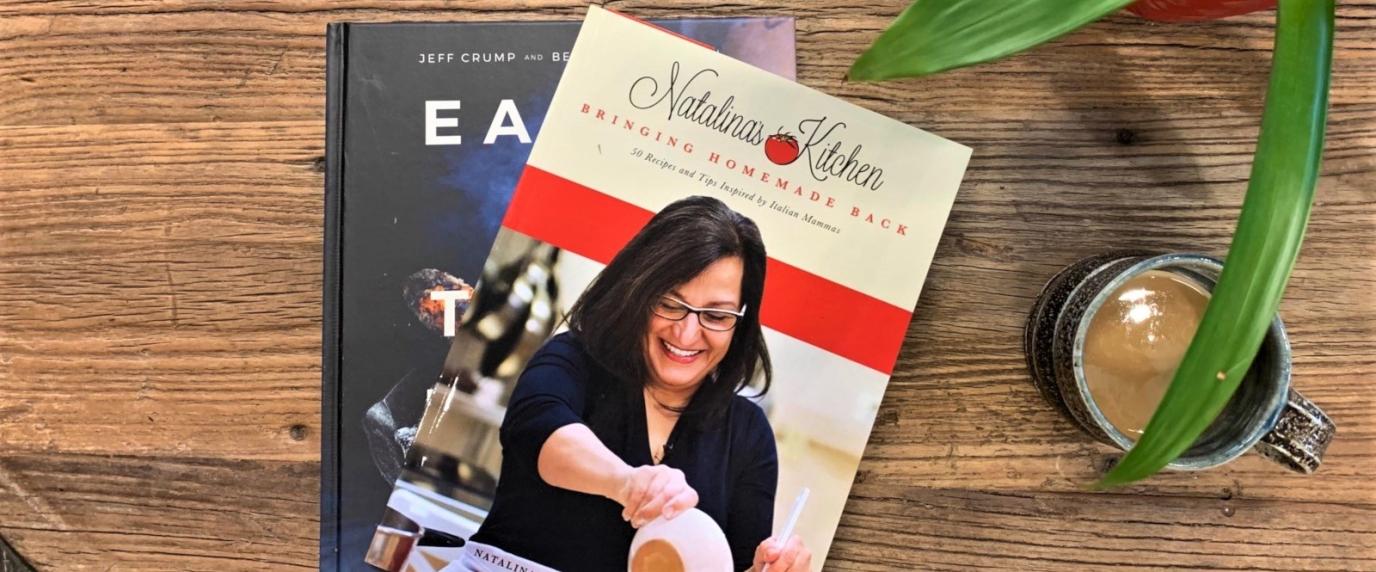 cookbooks sitting on table with coffee and plant